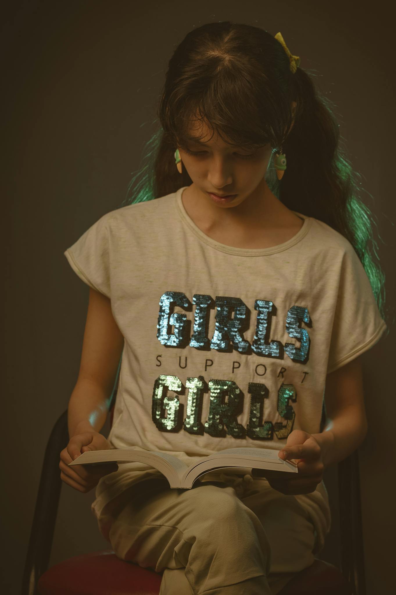 Teenage girl reads a book indoors, illustrating learning and support themes.